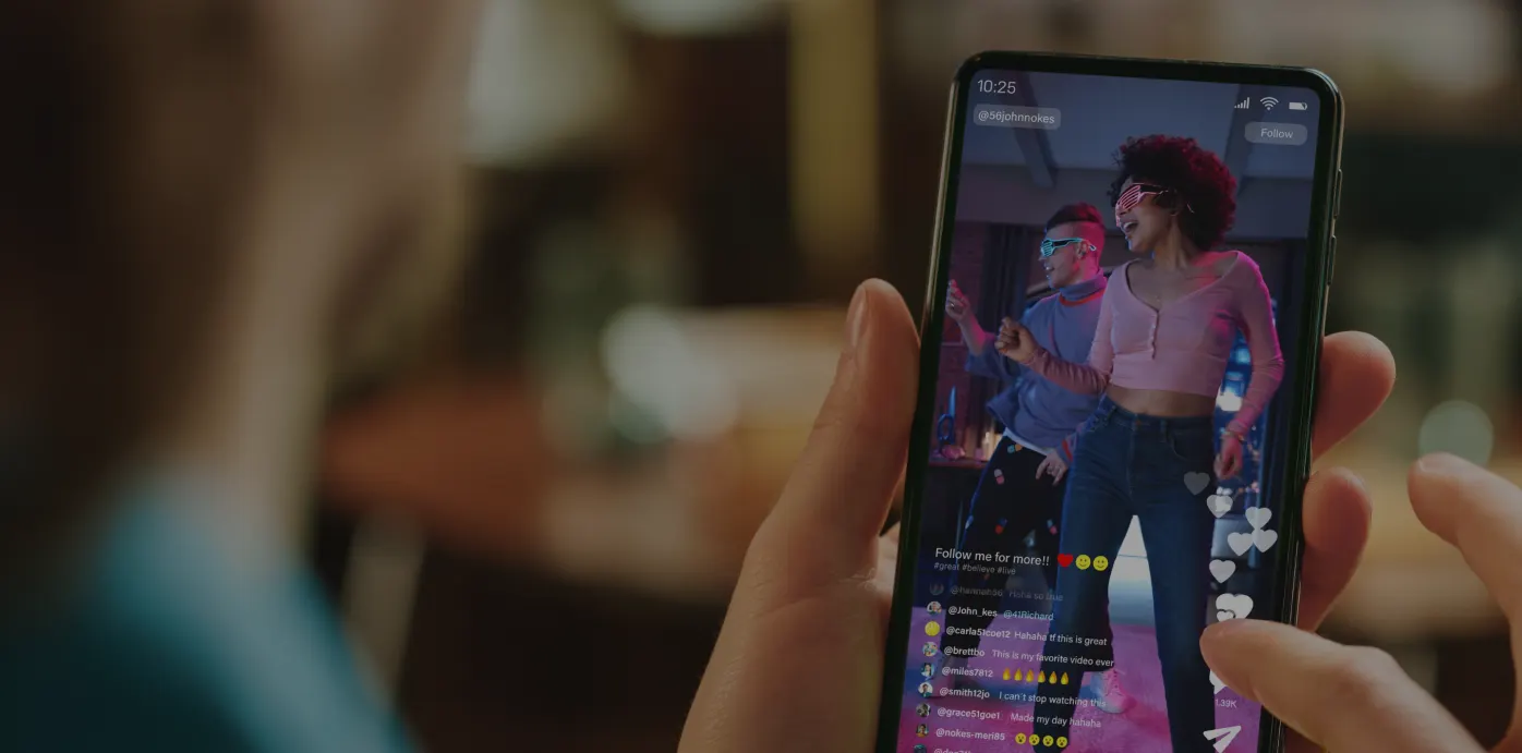 Smartphone screen showing a live TikTok broadcast with a content creator dancing and engaging with viewers.